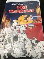 Front cover case showing colorful 101 Dalmatians artwork with multiple Dalmatian dogs and Cruella de Vil in the background.