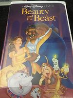 Front cover of Walt Disney Classic Beauty and the Beast VHS tape showing animated characters Belle, Beast, Mrs. Potts, Chip, Cogsworth, and Lumière with the title on a dark background.