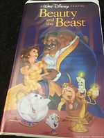Front cover sleeve of Walt Disney Beauty and the Beast VHS showing colorful illustration of main characters including Belle, the Beast, and enchanted household objects.