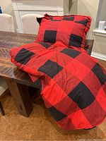 Two buffalo plaid pillows sitting on a table.