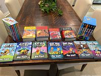 Full view of all 14 books displayed on table showing their colorful covers and boxed set.