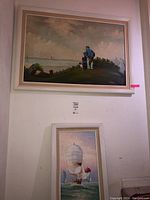 Photo showing both framed paintings one above the other on a wall, capturing the overall presentation and scale.