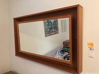 Front-facing view of rectangular teak mirror and bottom shelf
