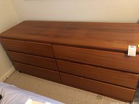 Front view of the six drawer Danish modern style dresser with natural wood finish and recessed handles.