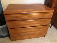 Front view of the wooden 3 drawer dresser showing drawer fronts and integrated handle grooves.