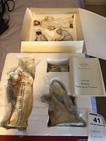 Photo of the nativity figurines in original styrofoam packaging with box showing the Lenox Lifetime Breakage Replacement Program booklet.