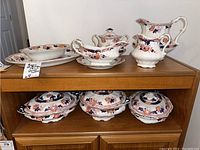 Overview of serveware pieces including platters, lidded dishes, gravy dish, and pitchers all decorated in the Yeddo floral pattern with blue and orange accents.