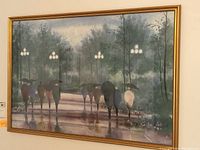 Framed wall art print showing park scene at night with people holding umbrellas walking on a wet path, illuminated by street lamps and surrounded by trees.