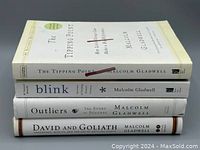 Four stacked books by Malcolm Gladwell, showing spines with titles and author name.