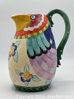 Front and side views of colorful Fitz & Floyd parrot jug showing detailed painted floral and checkered patterns and whimsical design.