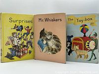Three vintage hardcover books standing upright showing front covers: Surprises (yellow), Mr Whiskers (beige), The Toy-box (light blue)