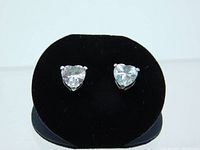 Front view of two clear heart-shaped cubic zirconia stud earrings on black display stand showing the stones and prong setting.