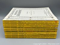 Side view stack of twelve National Geographic 1966 magazines with two index books on top.