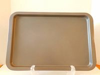 Front view of medium-sized rectangular non-stick cookie sheet with raised edges
