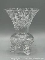 Front view of the clear brilliant cut crystal footed vase with intricate pinwheel design and three rounded feet.