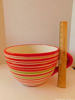 Large coffee cup-shaped planter with red, white, and green horizontal stripes and large handle, shown next to ruler for size reference.
