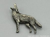 Front view of howling wolf shaped pewter brooch with detailed textured fur.