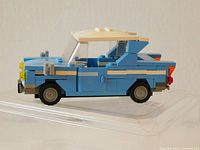 Side view of blue and beige LEGO flying car with working wheels and detailed body construction