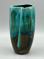 Front view of green and black drip glaze pottery vase showing the prominent drip effect and glossy finish.