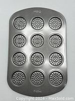 Full view of Wilton metal cookie sheet with 12 circular molds for making patterned cookies.