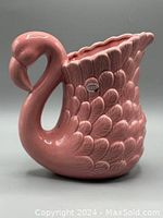 Side view of pink flamingo ceramic jug showing texture, curvature and glossy finish