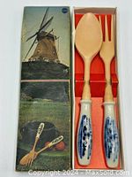 Image showing the boxed salad serving set with the blue and white Delft ceramic handles and resin spoon and fork inside the box, with box cover featuring traditional Dutch windmill artwork.