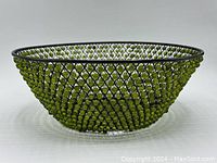 Full view of green and black bead wire bowl showing shape and color