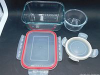 Top view showing rectangular and round containers and their lids, all clear glass and transparent lids with snap locks.