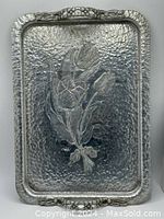 Full view of the rectangular hammered aluminum tray showing the floral tulip engraving and handles