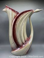 Photo of ceramic swan vase showing flowing curves, burgundy and cream glaze, and detailed finish