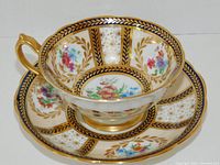 Cup placed inside saucer showing exterior pattern and gilt decoration