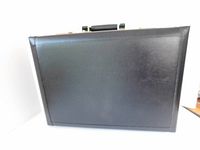 Photo of the front exterior of the briefcase showing smooth black leather surface.