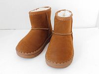 Front view of the light brown faux fur lined kid's slip-on boots showing the sueded upper and round toe design.
