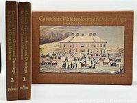 Front view of the two hardcover books standing upright alongside slipcase box, showing titles and detailed historic artwork on front of slipcase.