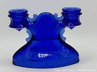 Front view of the cobalt blue glass double candle holder showing its shape and color.