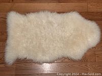 Top view of the white sheepskin showing full size and fluffy wool texture.