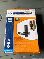 Photo of unopened B-Tech Ultragrip Pro loudspeaker wall mounts in original packaging with product details and image of mount and speaker.