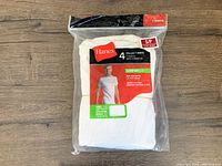 Packaged set of four Hanes men's tagless T-shirts in white, size small, new condition with opened package, one pack remaining.