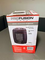 Photo of the ProFusion ceramic heater box showing product details including adjustable thermostat, 2 heat settings, power indicator light, and overheat protection.