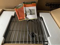Wolfgang Puck oven with manuals, metal rack, and power cord in box with styrofoam packaging