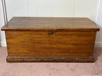 Front view of vintage cedar chest with wood grain and keyhole on front panel