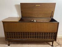 Top view focusing on open lid and interior of the stereo console cabinet showing Electrohome label and components with cord included in cabinet.