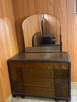 Front view of the dresser with attached mirror showing the drawer layout and mirror shape.