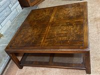 Top and side view of vintage wooden coffee table with wood grain top and woven bottom shelf