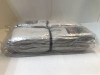 Closed clear plastic packaging containing 12 pairs of white men's socks folded and bundled with black elastic band.