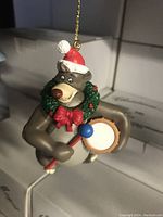 Photo of vintage Baloo Bear Christmas tree ornament hanging and illuminated.