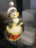 Close-up photo of a vintage Disney Thumper Christmas tree ornament in new old stock condition, showing Thumper standing on a drum wearing a Santa hat.