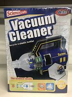 Front box photo showing Science Crafts Vacuum Cleaner kit designed for ages 8+, with features like recycling a plastic bottle, motor and fan parts included.