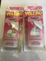 Front view of two Velcro Brand Fasteners heat-activated adhesive tape packs, showing product size and usage details