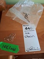 Photo of 10K gold chain and label on a wooden surface with notes.